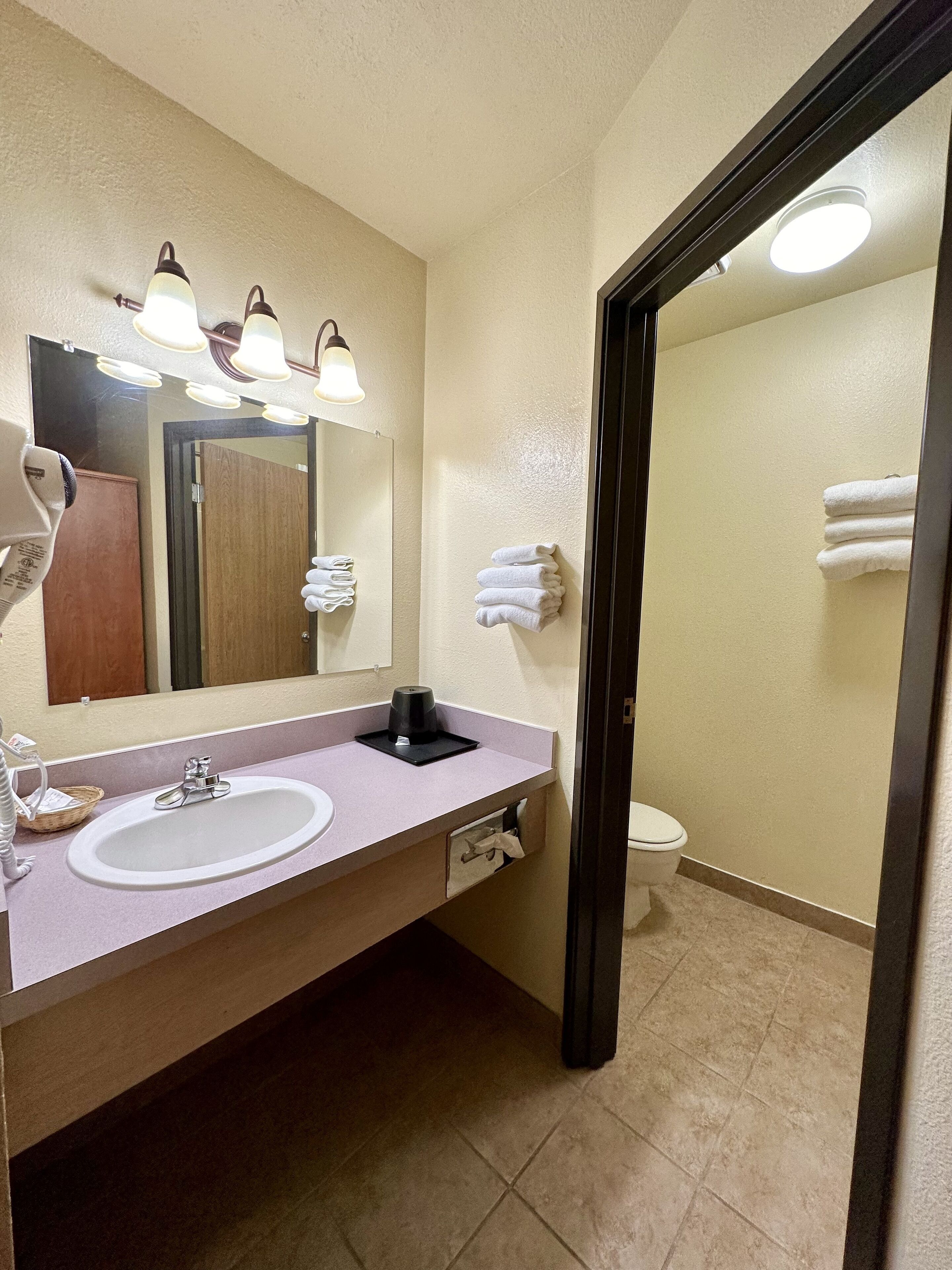 A bathroom with a sink, mirror, and towel rack.
