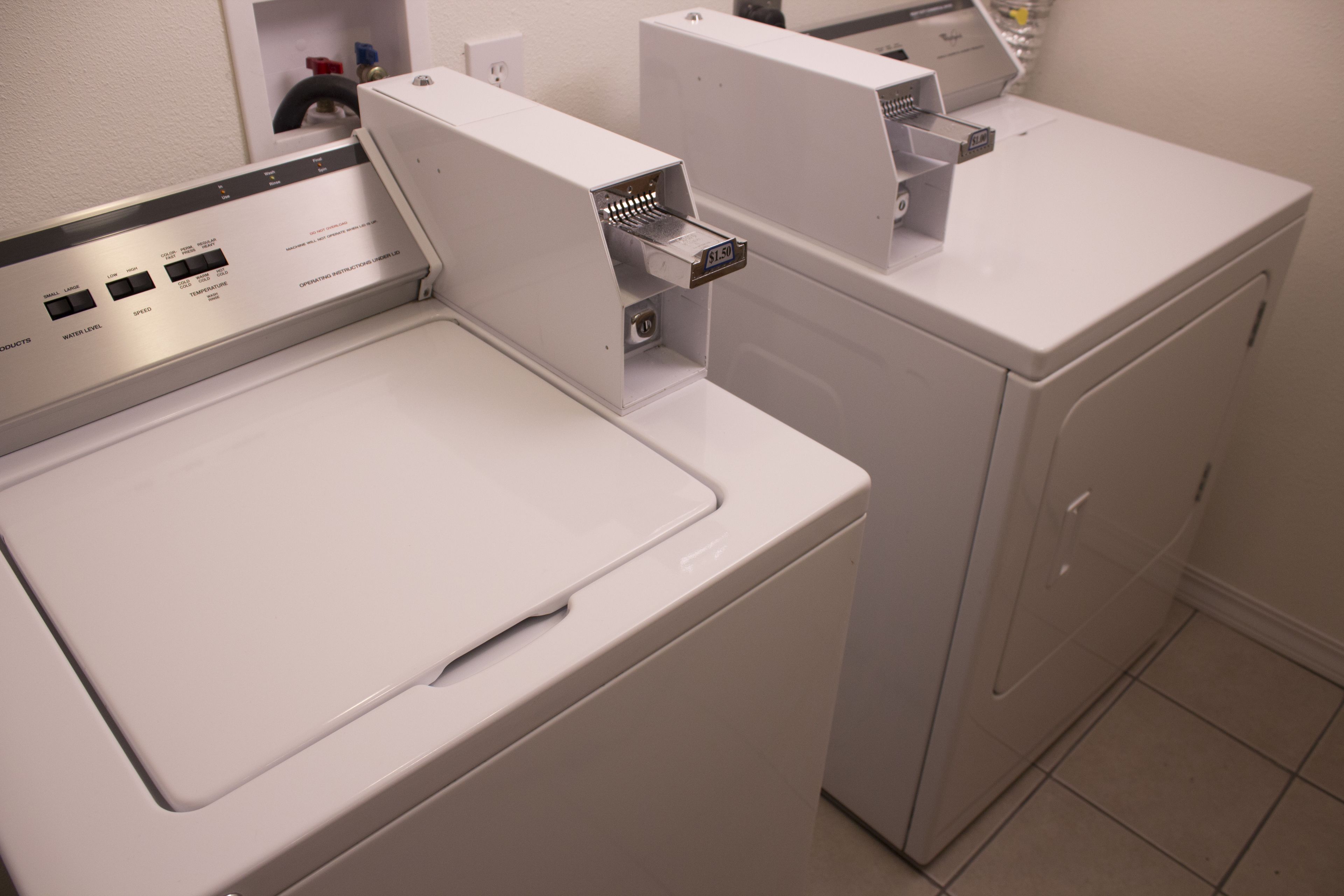 A front view of a modern laundry room with a front-loading washing machine and a stacked dryer.