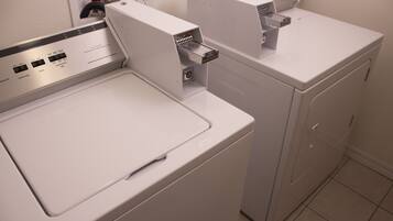 A front view of a modern laundry room with a front-loading washing machine and a stacked dryer.