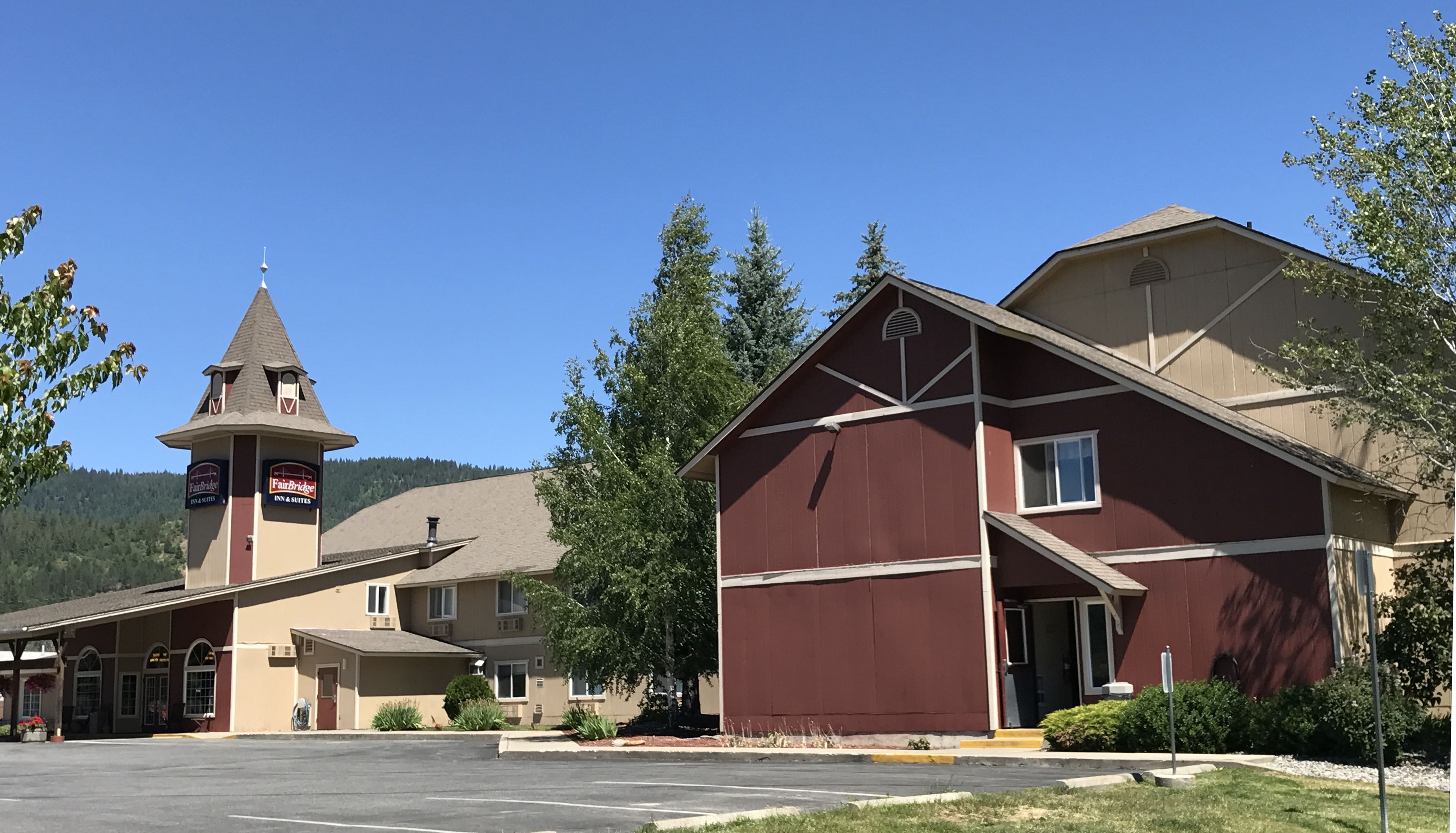 A hotel with a tower, a main building, and a parking lot.