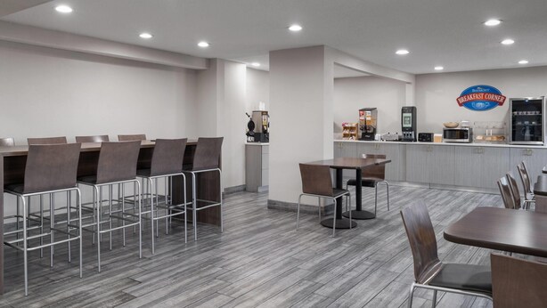 A breakfast area with a counter, seating, and kitchen appliances.