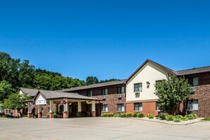 A hotel with a brick facade, a covered entrance, and a parking lot.