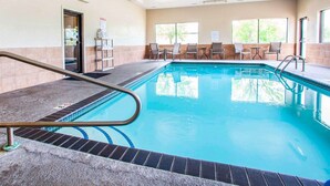 An indoor swimming pool with a tiled floor, a pool ladder, and several chairs around the pool. - Quality Inn & Suites Ankeny - Des Moines (Ankeny)