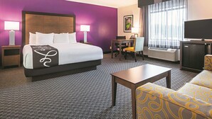 A hotel room with a bed, bedside tables, a desk, a chair, a television, and a sofa. - La Quinta Inn & Suites by Wyndham Atlanta Midtown - Buckhead (Atlanta)