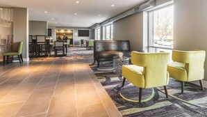 A spacious lobby with a seating area, a bar, and a dining area. - La Quinta Inn & Suites by Wyndham Atlanta Midtown - Buckhead (Atlanta)