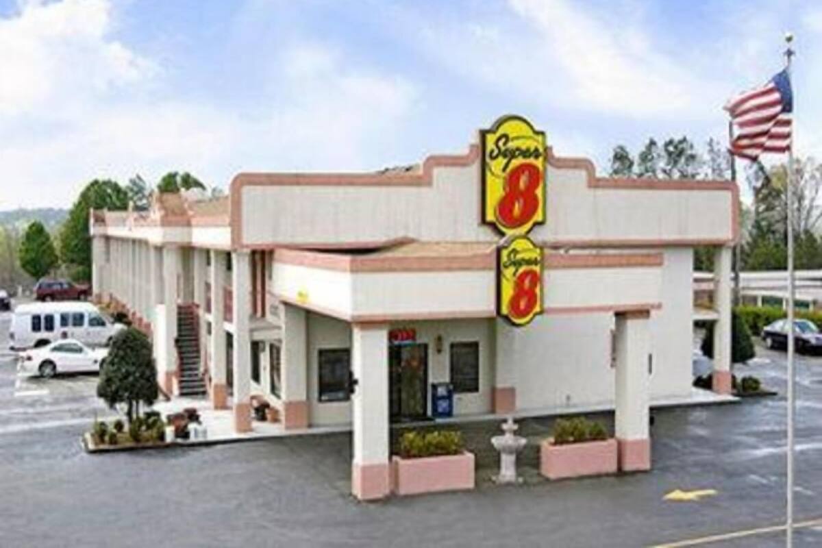A motel with a prominent '8' sign, a flag, and a parking lot.
