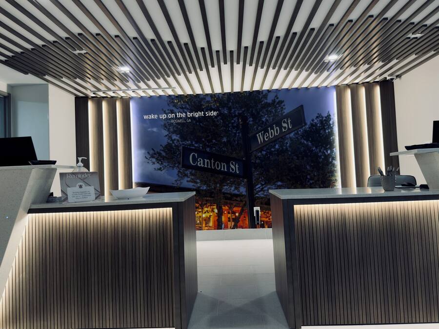 A reception area with a modern design, featuring a digital display with street names and a slogan.