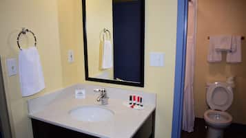 A bathroom with a sink, mirror, and toilet.