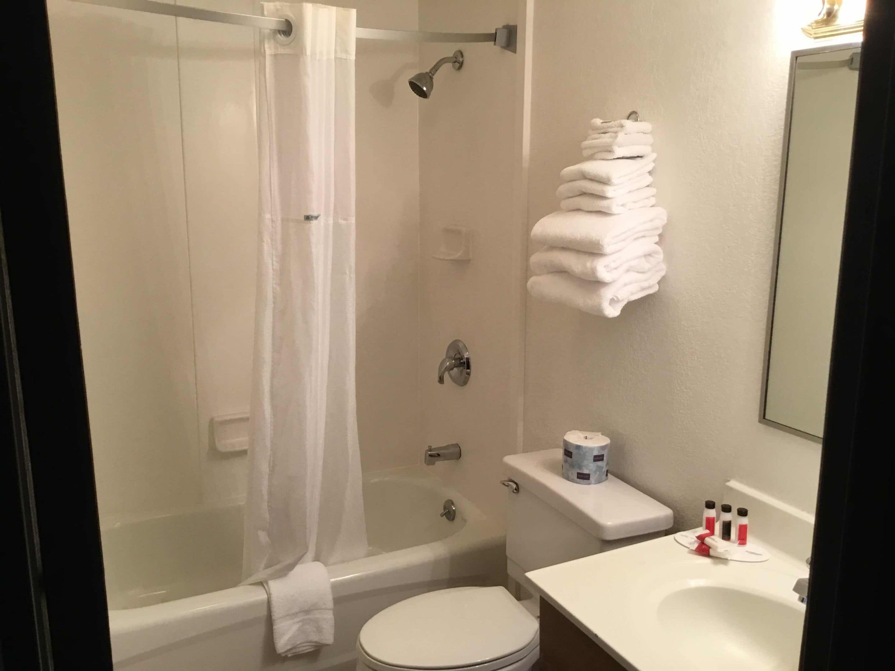 A bathroom with a bathtub, toilet, and sink.