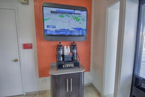 Un radar meteorológico en la pared, una cafetera y un armario en una habitación.