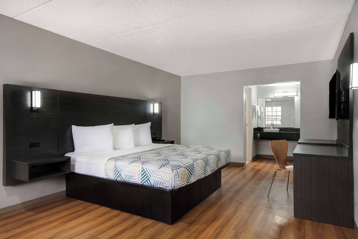 Une chambre moderne avec un grand lit, des tables de chevet, un bureau et une chaise.