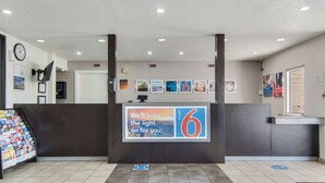 A hotel reception area with a prominent sign advertising the number 6.