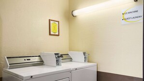A laundry area with an ice machine and guest laundry sign.