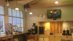 A restaurant with wooden furniture, a bar area, and a television mounted on the wall. - Super 8 by Wyndham Helena (Helena)