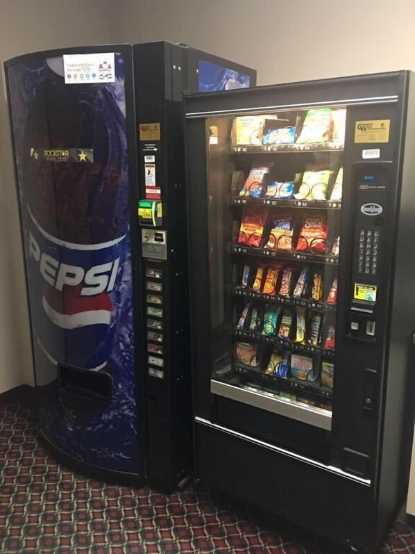 A vending machine with a Pepsi logo and a snack vending machine next to it.