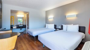 A hotel room with two beds, a desk, a sink, and a mirror. - Motel 6 Pleasanton, CA (Pleasanton)