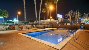A swimming pool with lounge chairs and umbrellas, surrounded by palm trees and a fence. - Best Western Poway/San Diego Hotel (Poway)