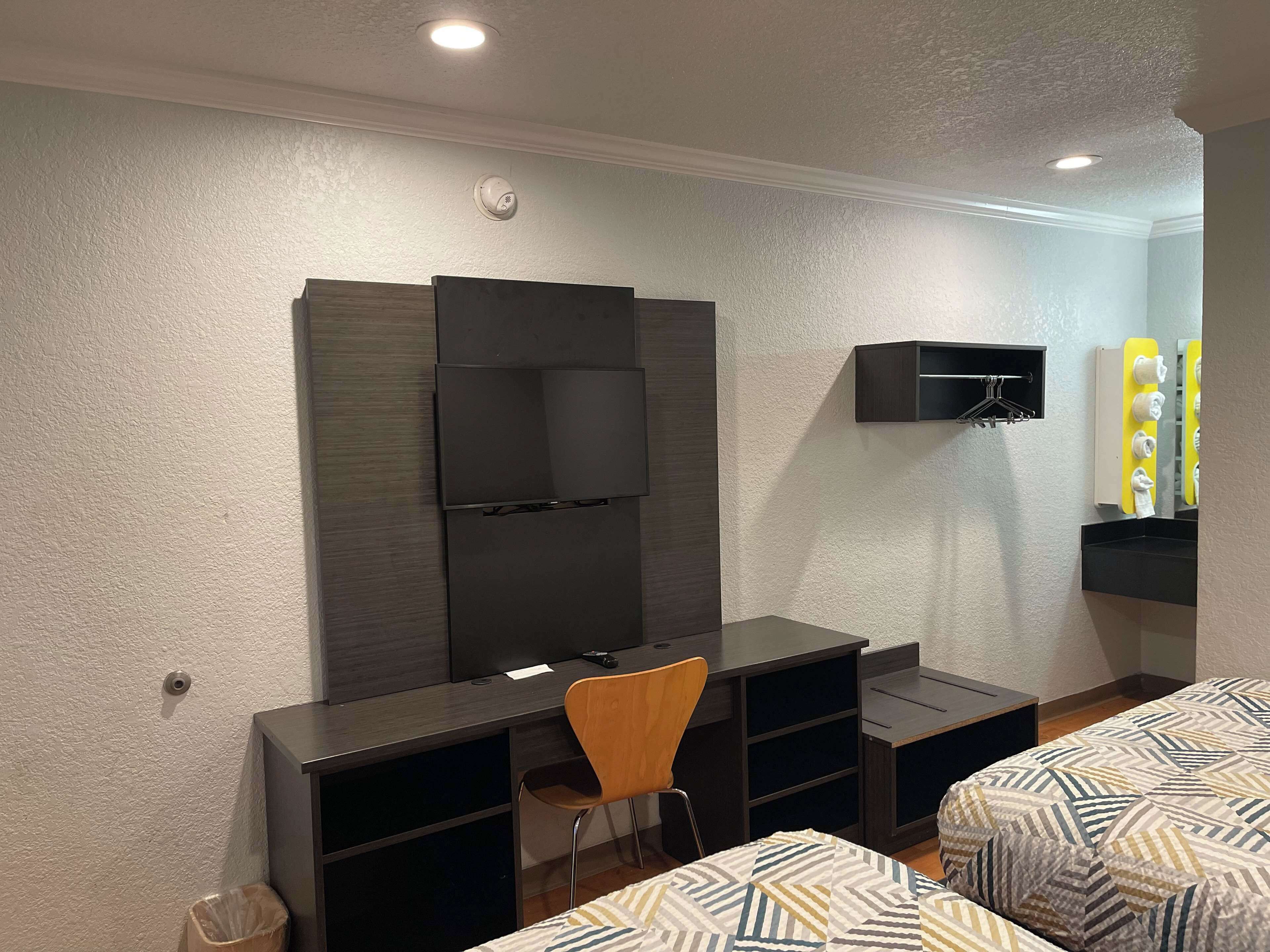 A bedroom with a desk, chair, and two beds.