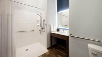A modern bathroom with a shower, toilet, and sink.