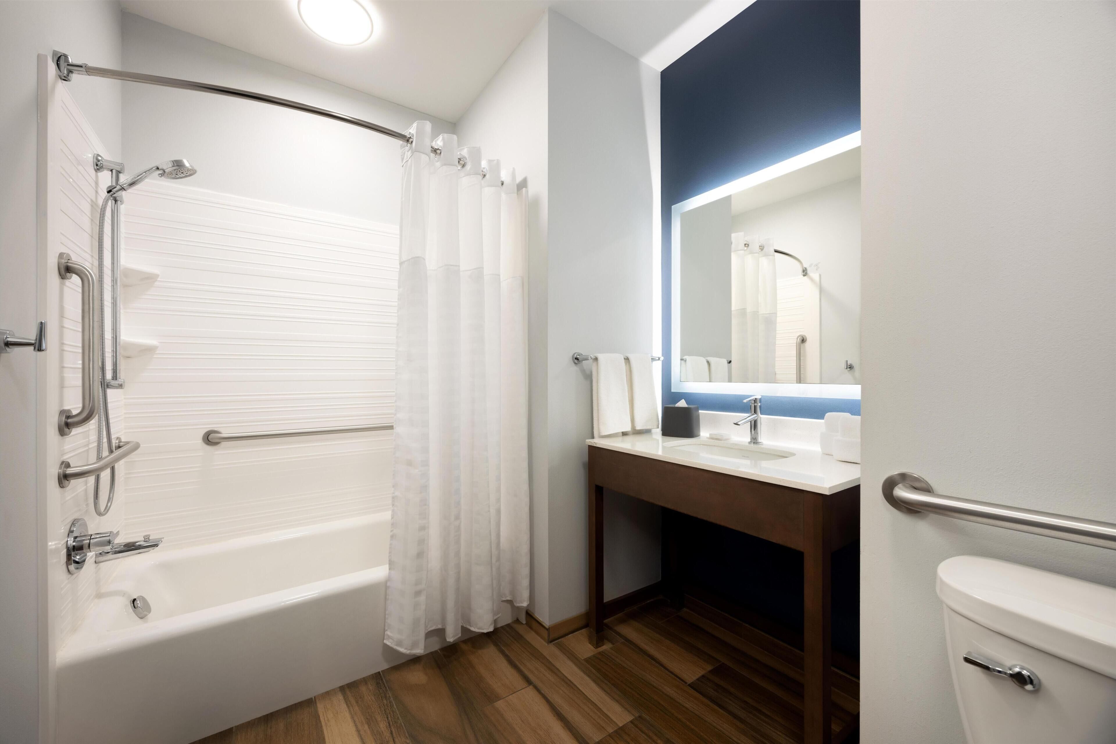 Ein Badezimmer mit Badewanne, Toilette, Waschbecken und Spiegel.
