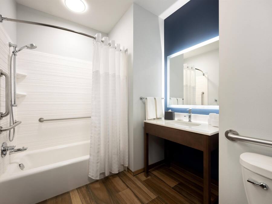 A bathroom with a bathtub, a toilet, a sink, and a mirror.