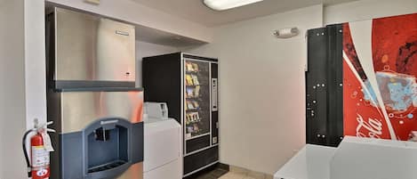 A kitchenette with a stainless steel range, a built-in ice maker, and a coffee machine.