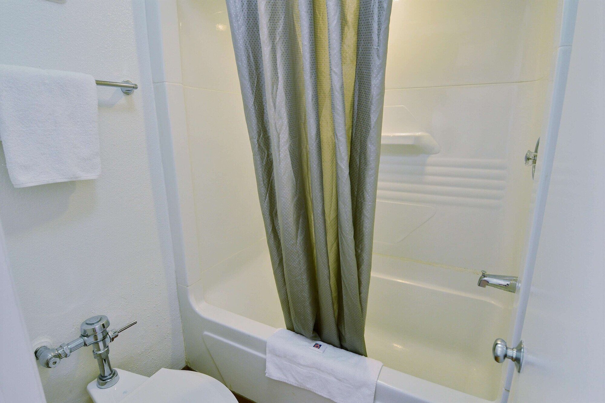 Un baño con bañera, inodoro y cortina de ducha.