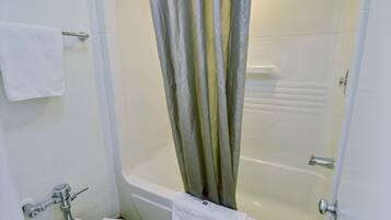 Un baño con bañera, inodoro y cortina de ducha.