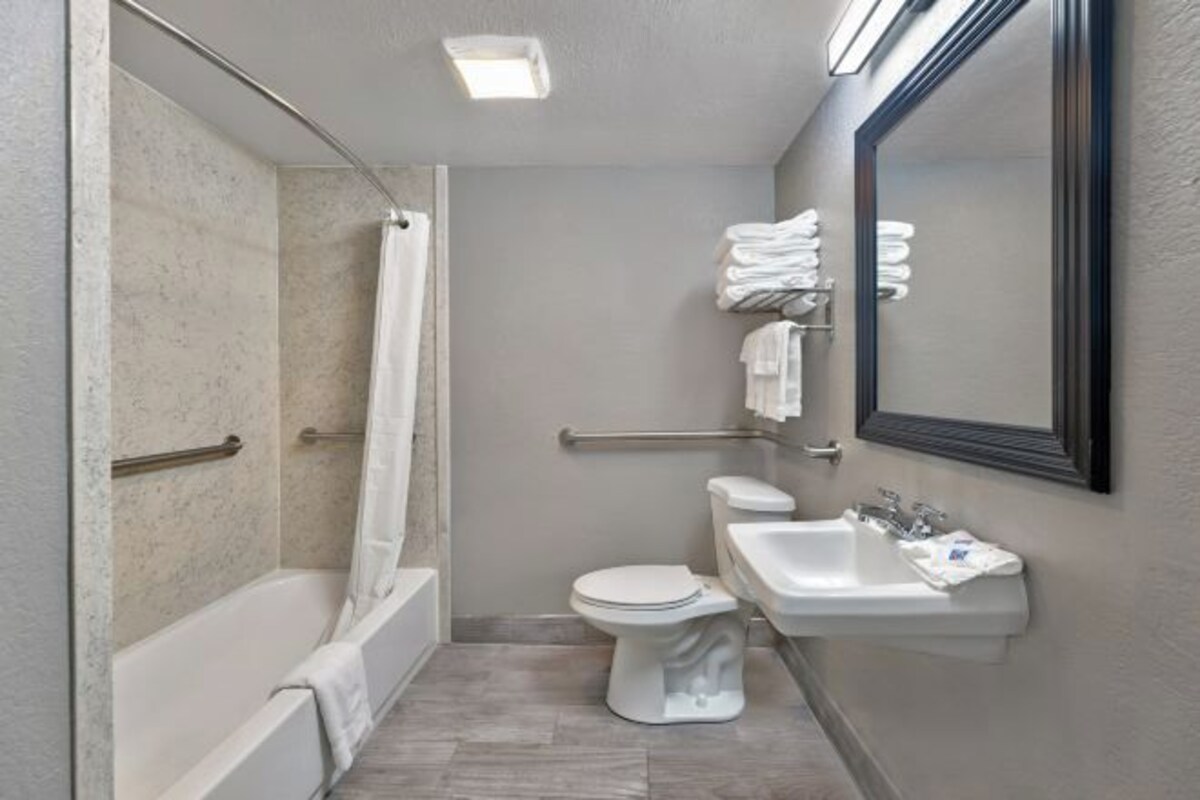 A small, modern bathroom with a bathtub, toilet, and sink.