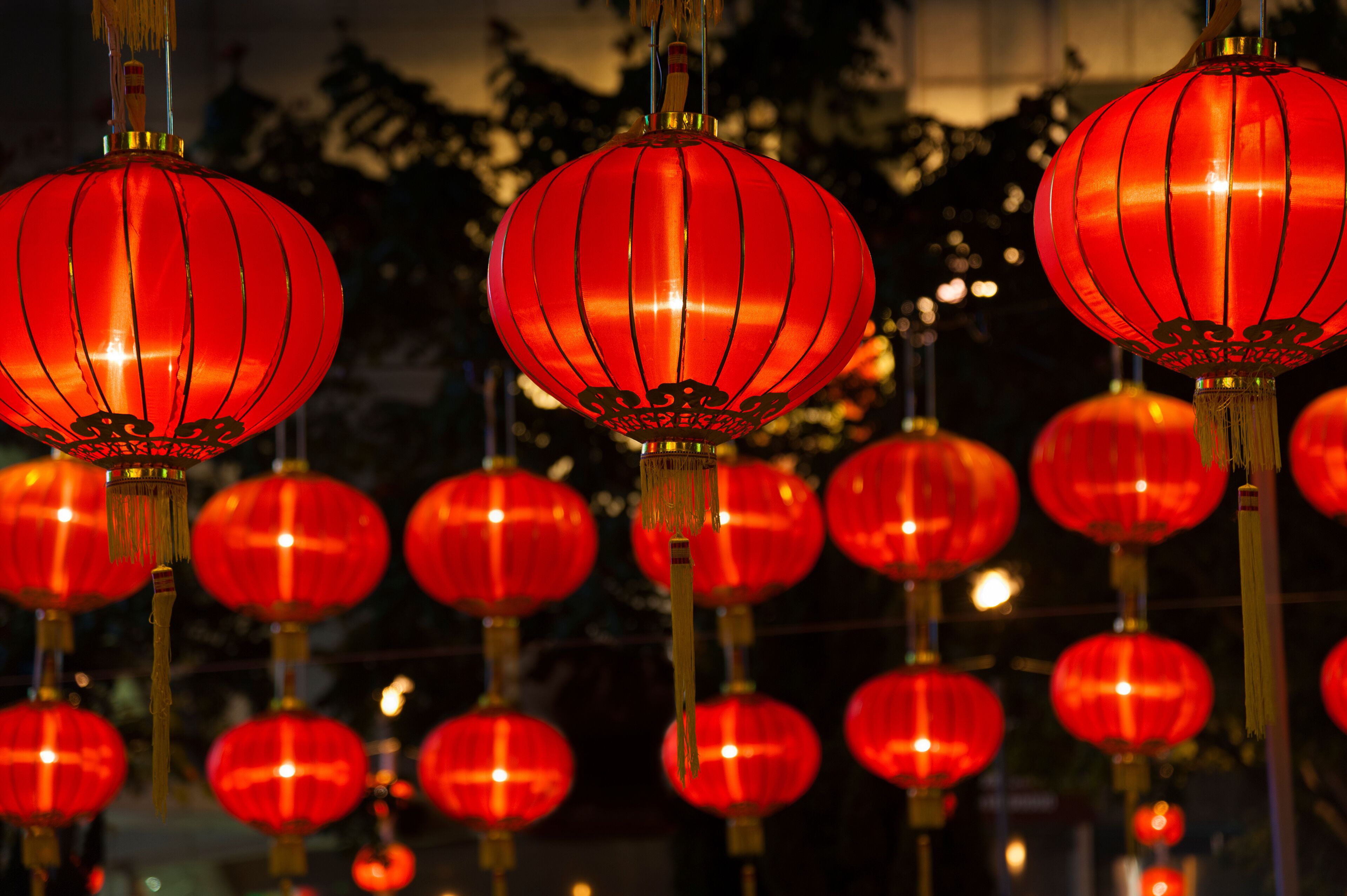 A row of red lanterns hanging outdoors at night.