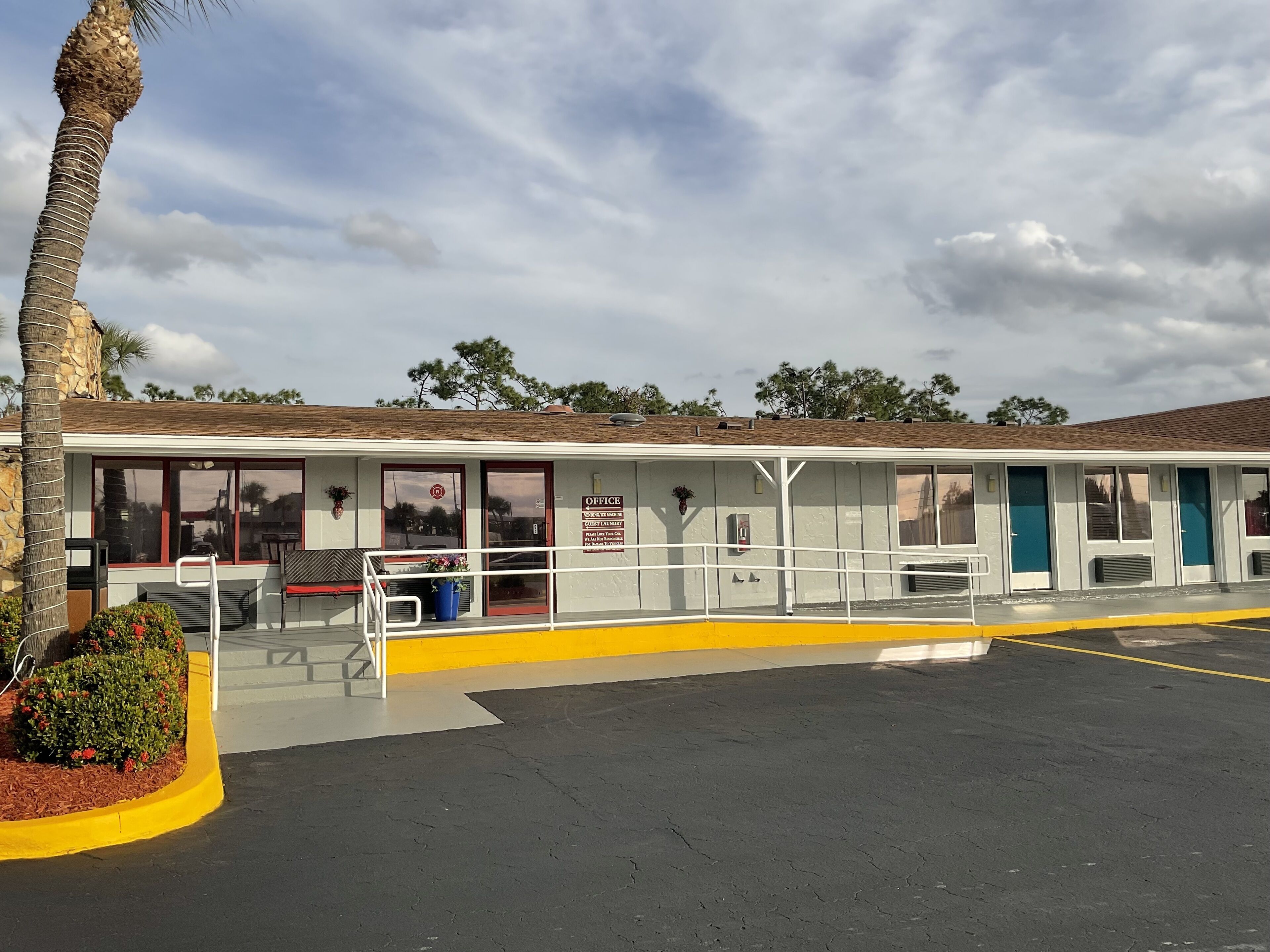 A building with a flat roof, large windows, and a yellow curb.