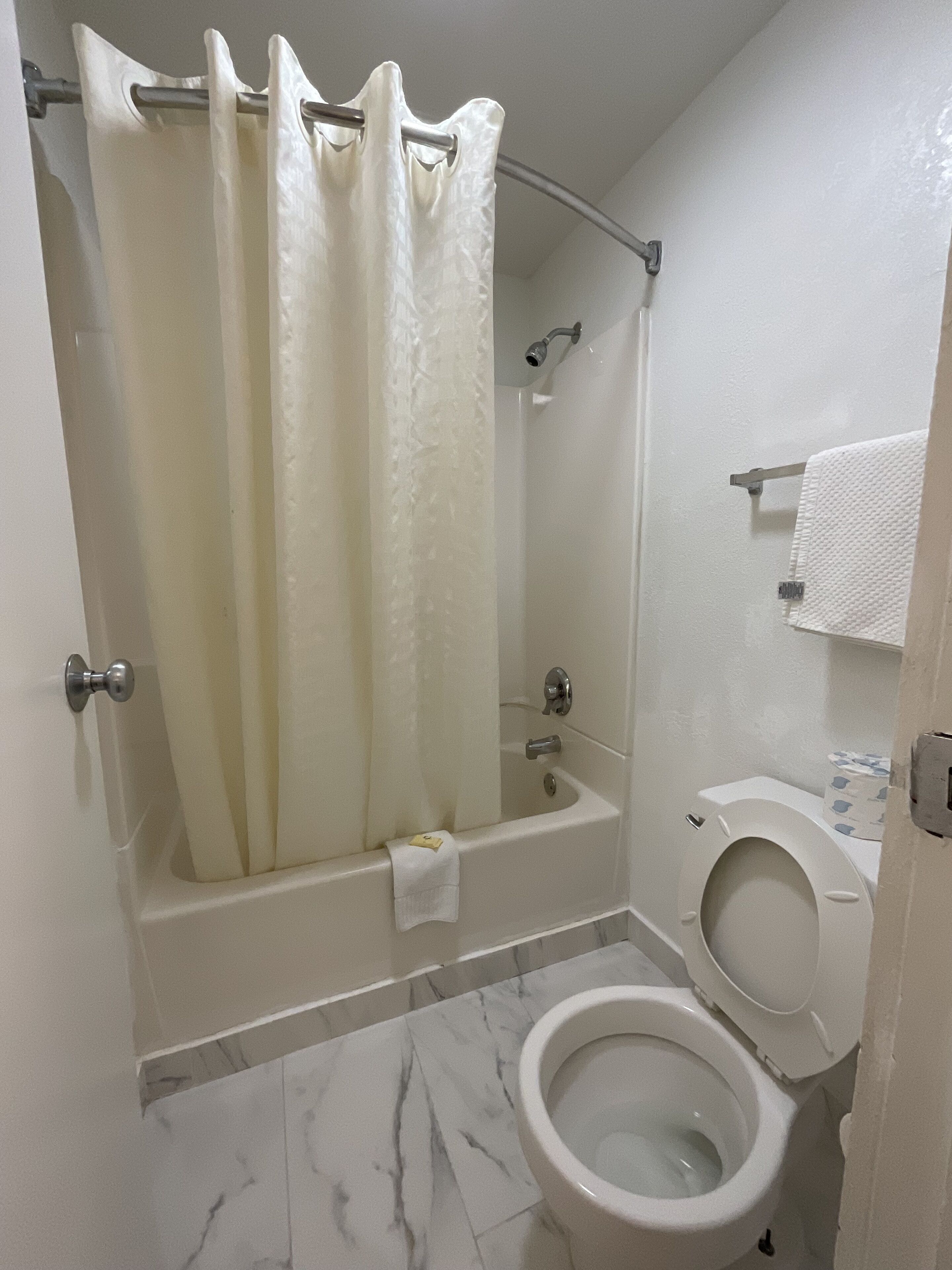 Un baño con bañera, inodoro y cortina de ducha.