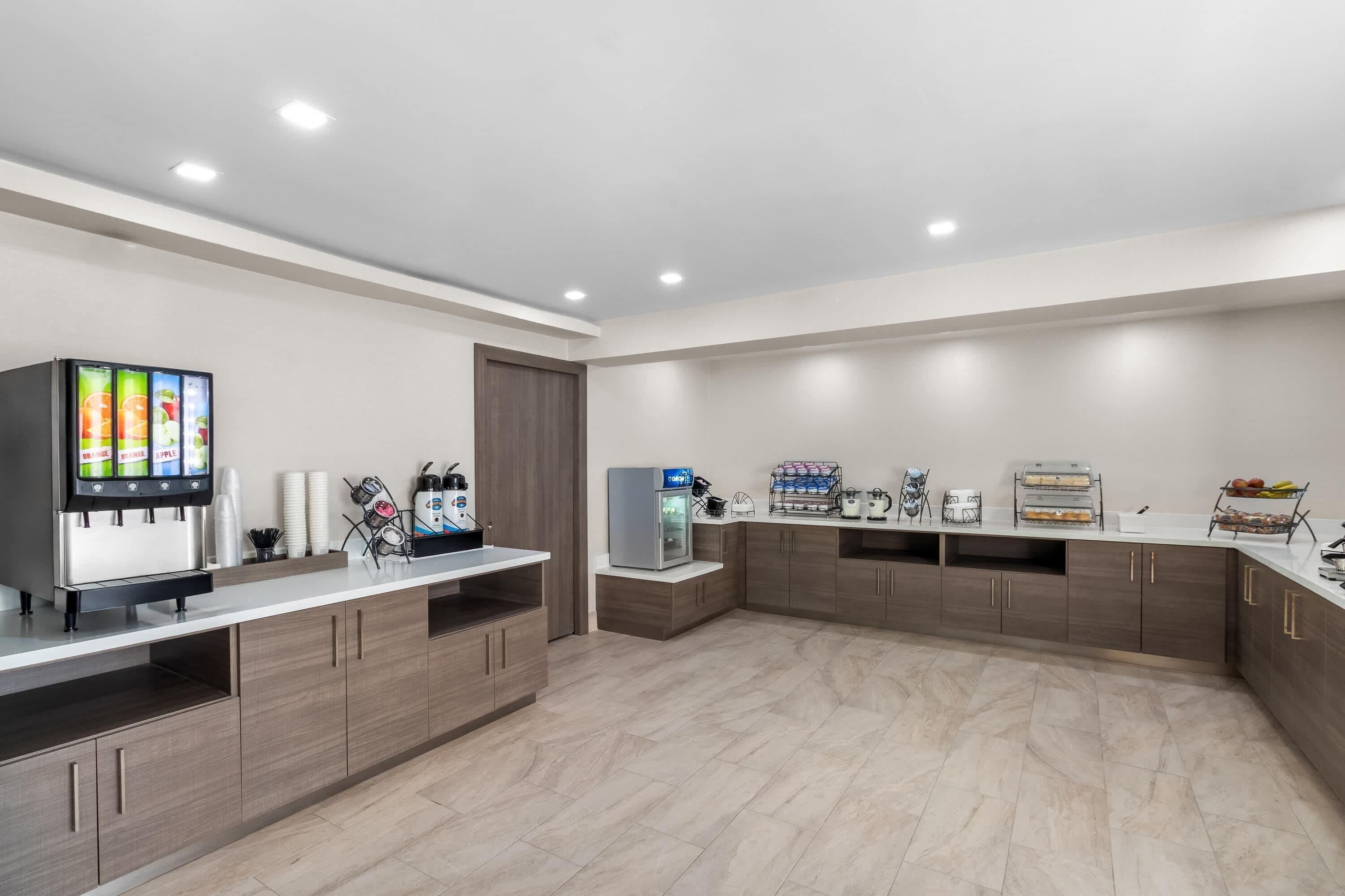 A modern kitchen with a built-in coffee machine, a refrigerator, and a microwave.