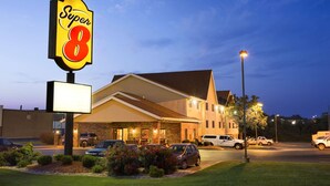 Un hotel Super 8 con un cartel grande, un estacionamiento y una entrada bien iluminada.