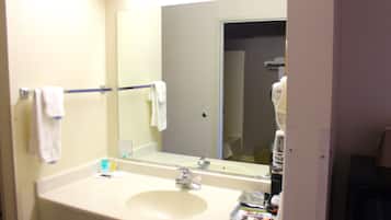 A bathroom with a sink, mirror, and towel rack.