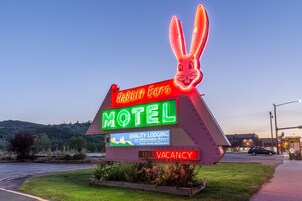 Letrero de motel iluminado con neón y un conejo como mascota, que indica disponibilidad.