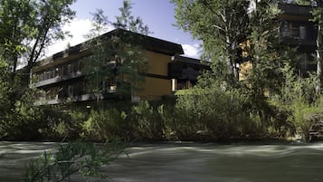 A modern building with multiple balconies overlooking a river.