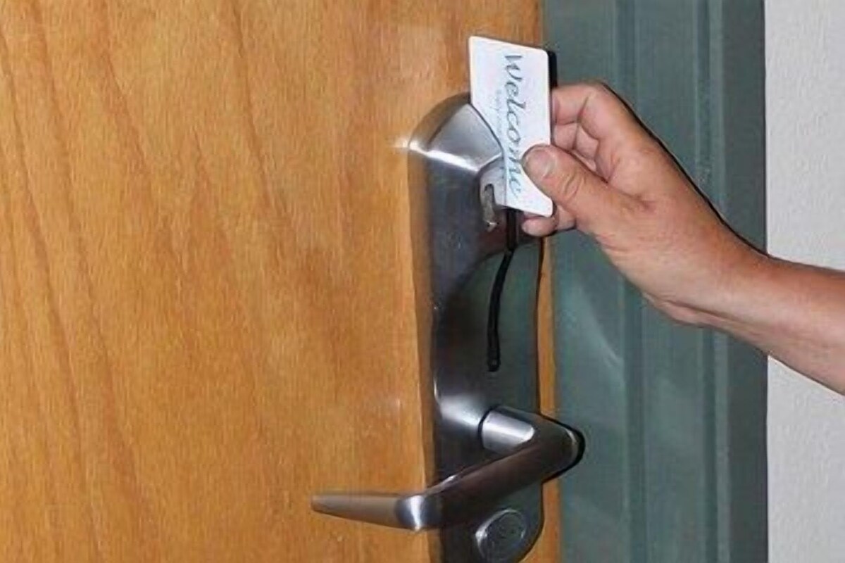 Una mano introduciendo una tarjeta en la cerradura de una puerta.