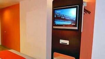 A hotel room with two beds, a TV mounted on the wall, and a red and white color scheme.