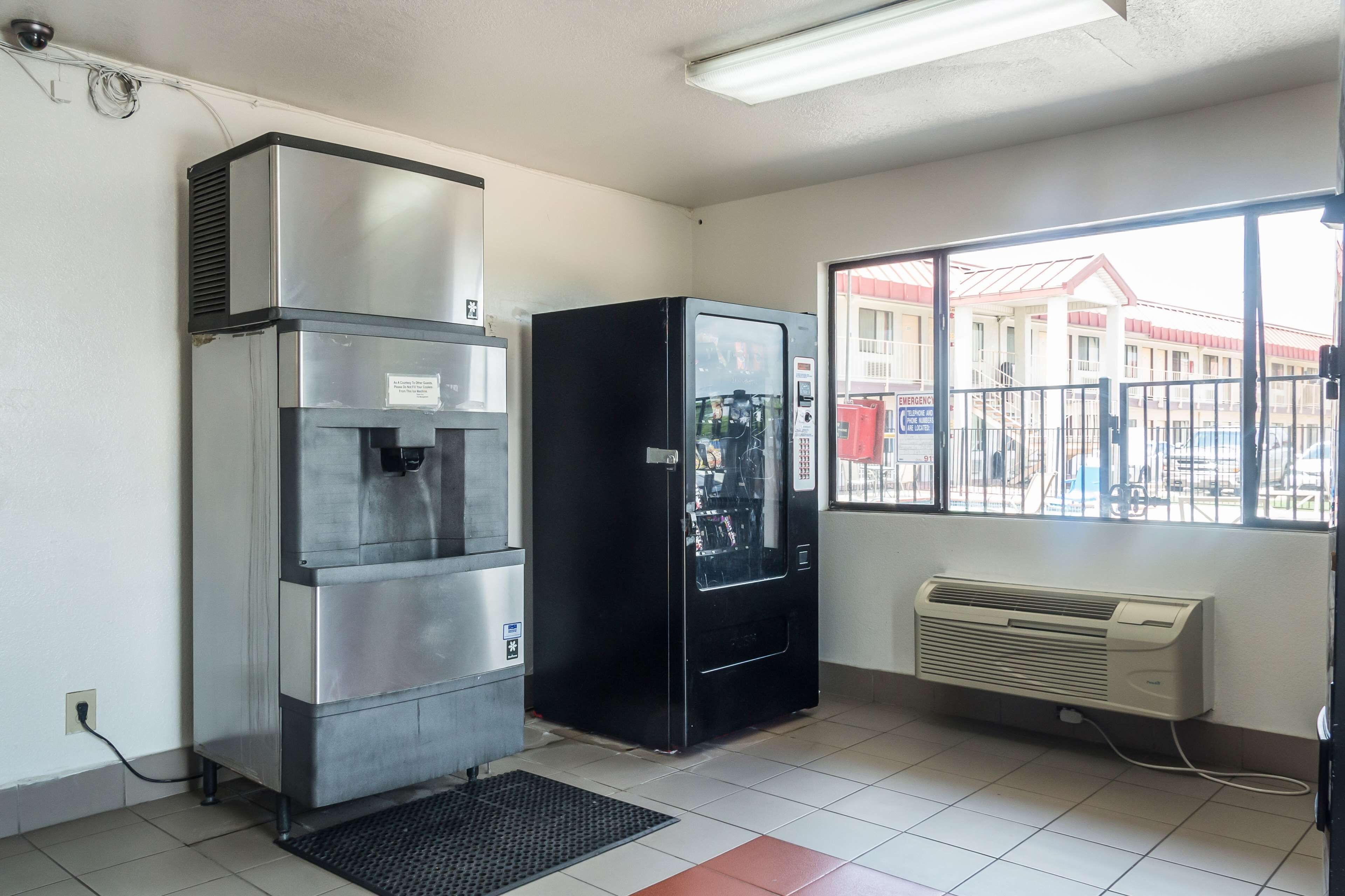 A room with a vending machine, a water dispenser, and an air conditioning unit.
