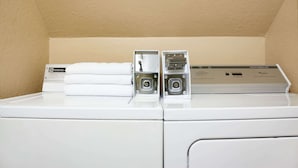 Un lave-linge à chargement frontal doté d’un panneau de commande et d’un sèche-linge placé au-dessus.