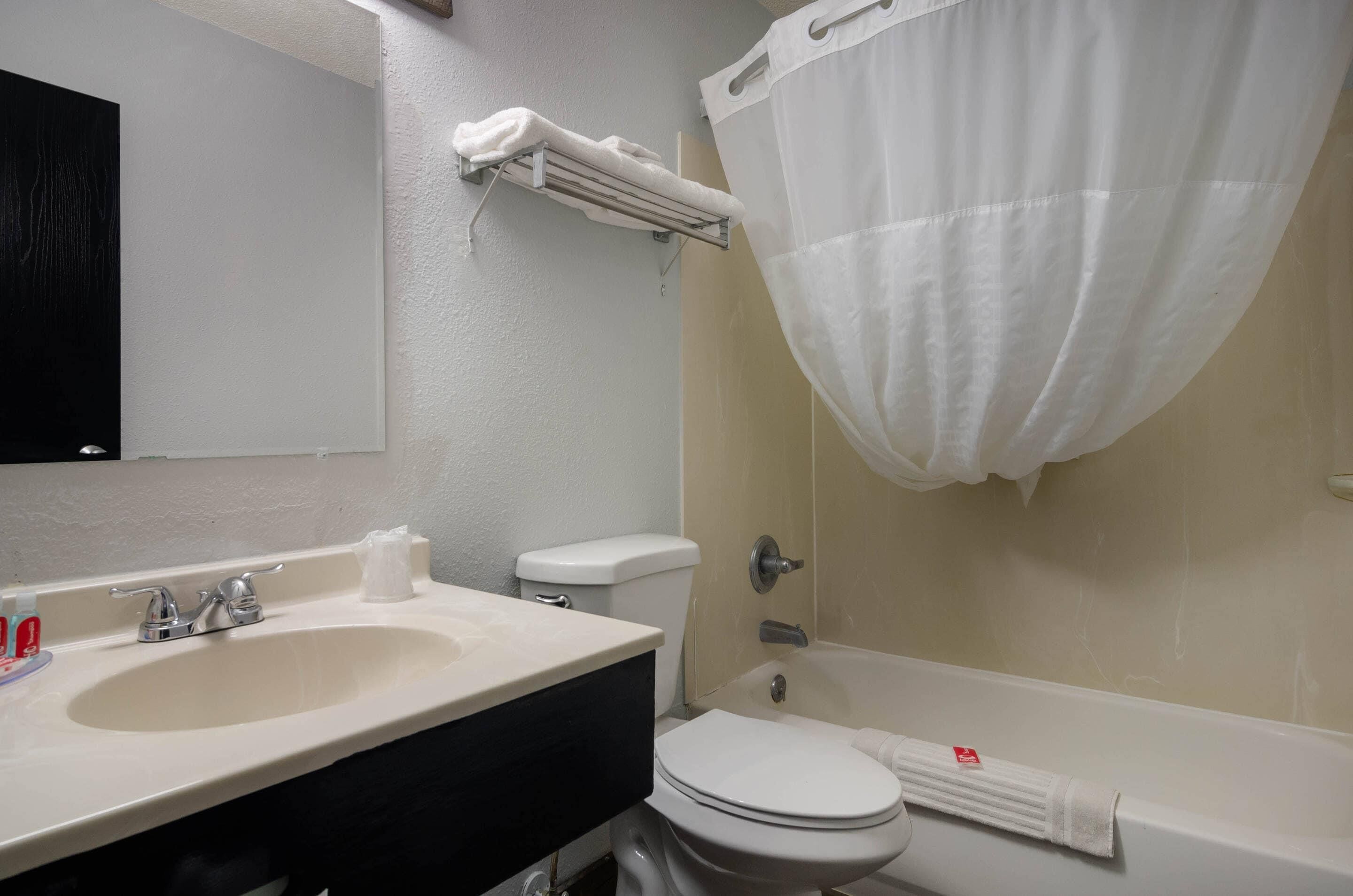 A bathroom with a sink, toilet, and bathtub.