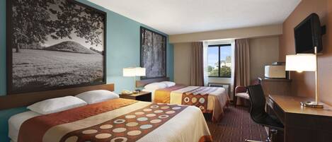 A hotel room with two beds, a desk, a chair, and a TV.