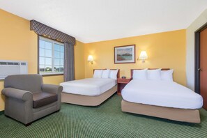 A hotel room with two beds, a chair, a window with curtains, and a painting on the wall. - Days Inn by Wyndham Great Bend (Great Bend)