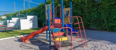 A playground with a slide, climbing structures, and a covered play area.