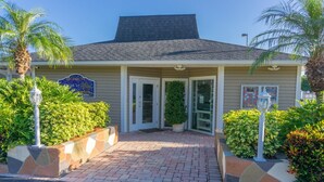 A building entrance with a tiled walkway, a sign reading "BAYVIEW PLACE," and a small potted plant.
