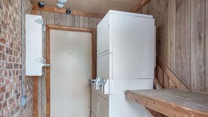 Cocina compacta con un refrigerador blanco, una encimera de madera y una puerta que da a otra habitación.