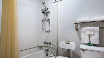 A bathroom with a shower, toilet, and towel rack.