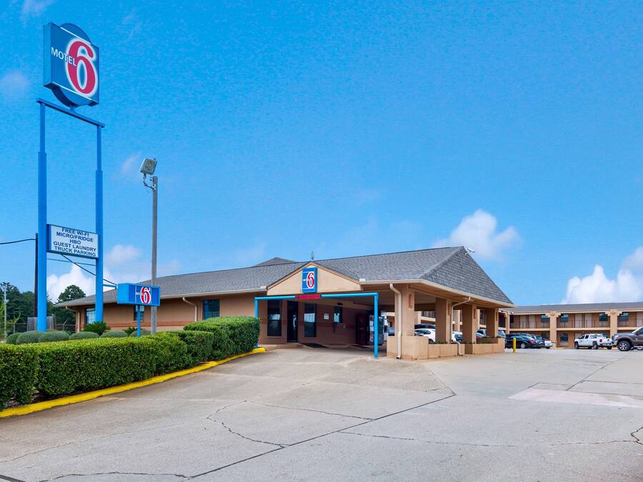 A motel with a large sign, a guest laundry service, and a parking area.