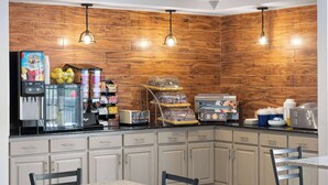 Una cocina con paneles de madera, un refrigerador, una cafetera y un lavamanos.